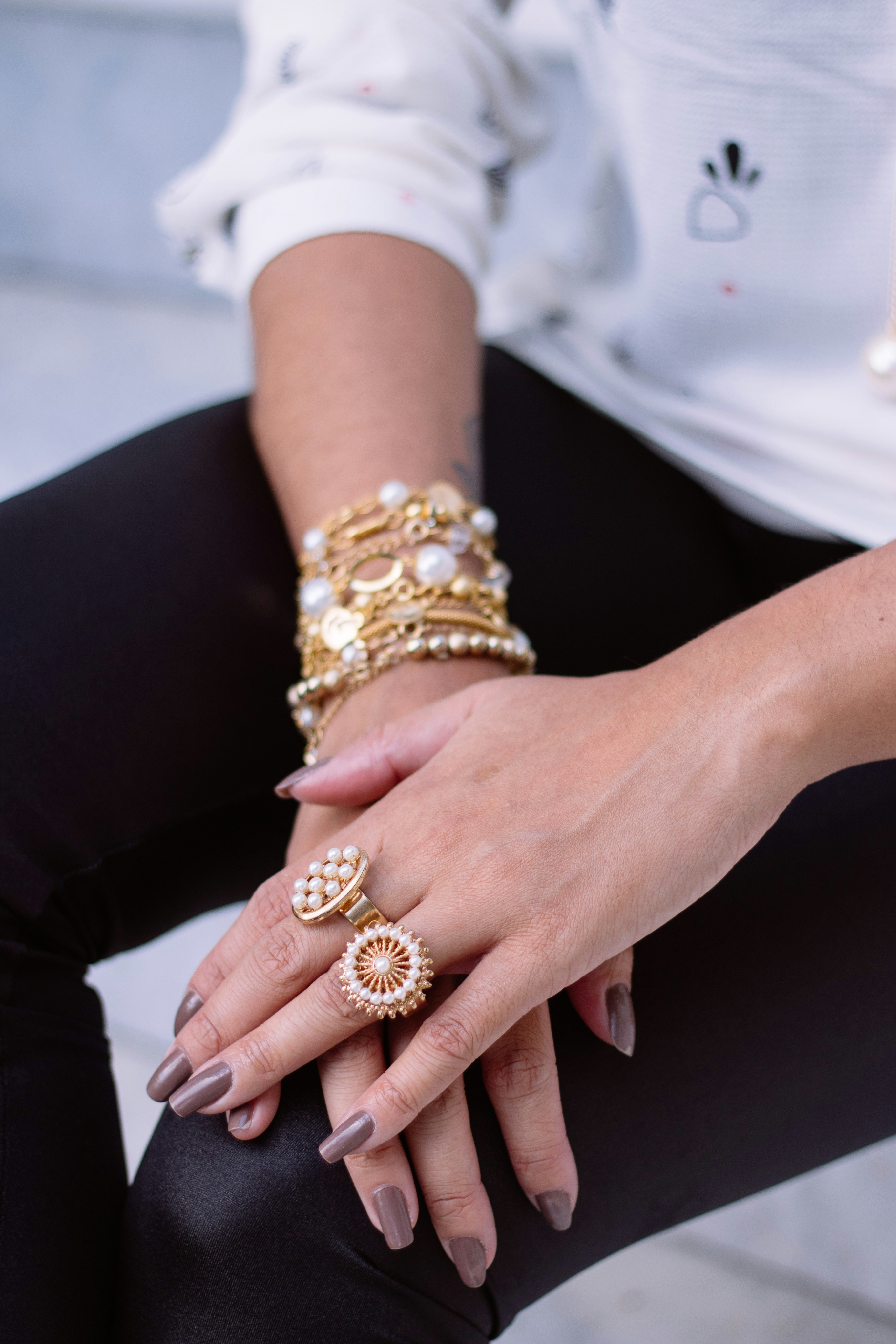 Hands wearing gold bracelets and rings